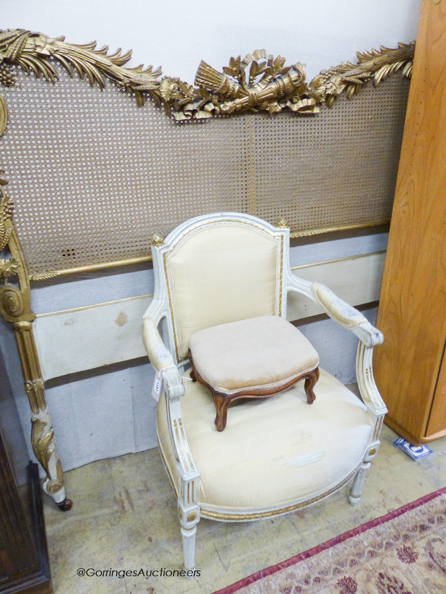 A carved giltwood and gesso caned headboard, width 164cm, together with a painted French elbow chair and a Victorian footstool